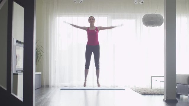 Young Woman doing Fitness at Living Room at Home. Shot on RED Cinema Camera.