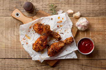 Roasted (griiled) chicken drumstick on cutting board