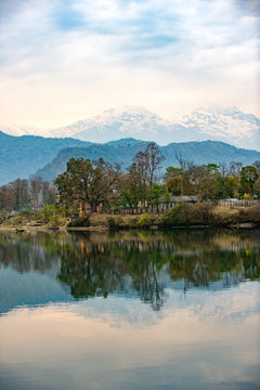 Lake Phewa in Pokhara, Nepal, with the Himalayan mountains in the background, including Machhapuchhre and Annapurna
