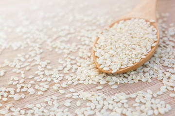 Sesame seeds with a wooden spoon