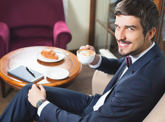 Handsome male has a french breakfast at cafe restaurant