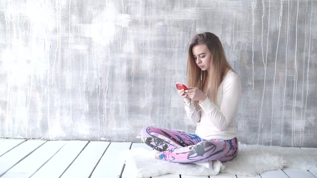 Happy teen girl listening to the music and chatting by smart phone taking selfies
