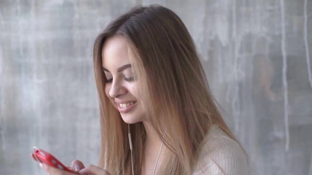 Happy teen girl listening to the music and chatting by smart phone taking selfies