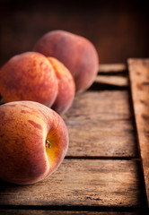 Peaches group on old rustic wooden box and dark background
