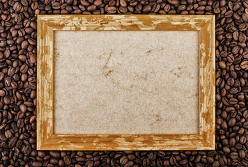 Coffee beans background with wooden picture frame. Top view with copy space.