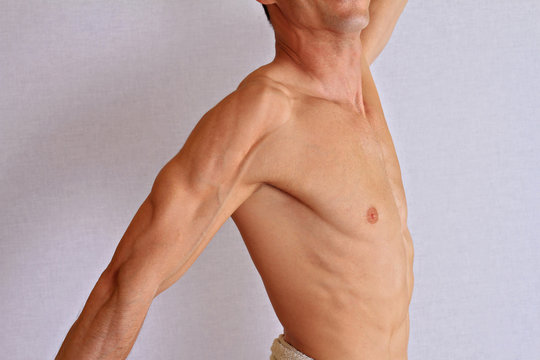 Muscular male torso, chest and armpit hair removal close up. Male waxing