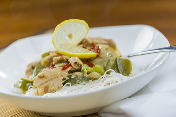 Closeup view of a bowl of thai green curry and rice vermicelli n
