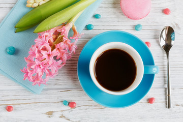 Cup of black coffee, pink flowers and french macaroons