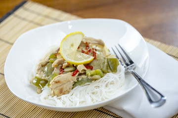 Closeup view of a bowl of thai green curry and rice vermicelli n