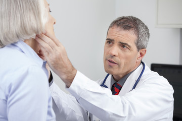 Fototapeta premium Doctor taking blood pressure of senior woman