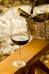 Wine glass and bottles in basket