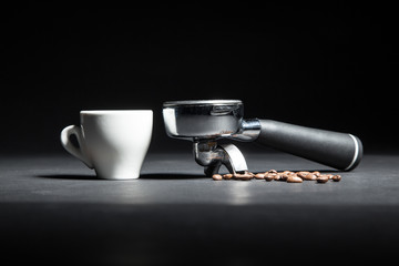 Obraz na płótnie Canvas artistic studio shot of holder for coffee machine, white cup and beans;