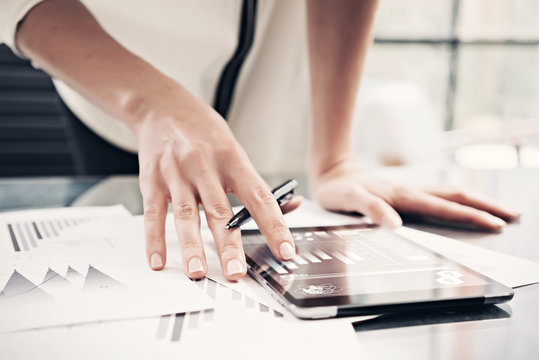 Photo woman reading market reports modern tablet and touching screen with worldwide stock exchange icons. Working process office. Horizontal. Film effect