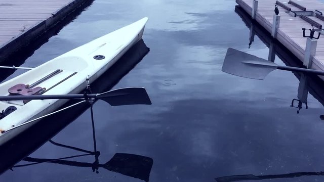 Empty rowing boat with oars floats on calm water in Lagoa, in Rio de Janeiro, Brazil