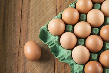 Fresh chicken eggs from the farm in a basket on a rustic wooden background