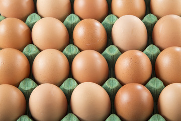 Fresh chicken eggs from the farm in a basket on a rustic wooden background