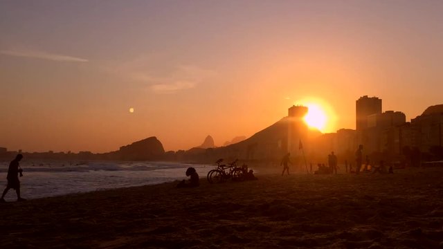 This video is about 20151020_rio00070_copatlGolden sun setting behind a silhouette of the Rio de Janeiro skyline at the Leme end of Copacabana Beach in time lapse