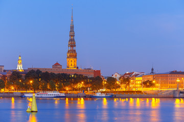 Fototapeta na wymiar Saint Peter church, Stone Bridge and River Daugava in the Old Town of Riga at night, Latvia