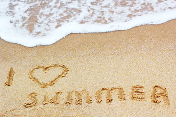 Inscription on wet sand I Love Summer. Concept photo of summer vacation.