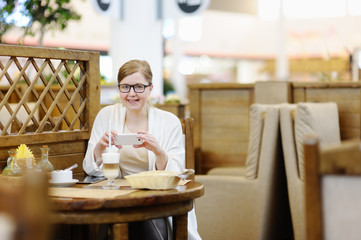 Portrait of a beautiful woman in a cafe. Blonde 40-45 years.