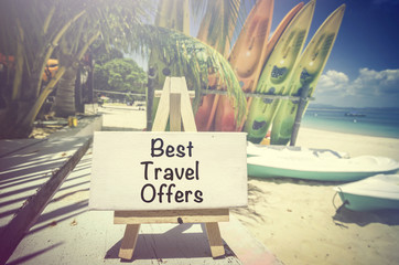 conceptual image with word BEST TRAVEL OFFERS on white canvas frame and wooden tripod.