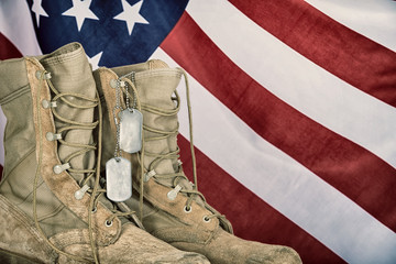 Old combat boots and dog tags with American flag