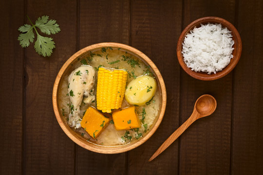 Traditional Chilean Cazuela de Pollo (or Cazuela de Ave) soup made of chicken, sweetcorn, pumpkin and potato, seasoned with fresh coriander, photographed on dark wood with natural light