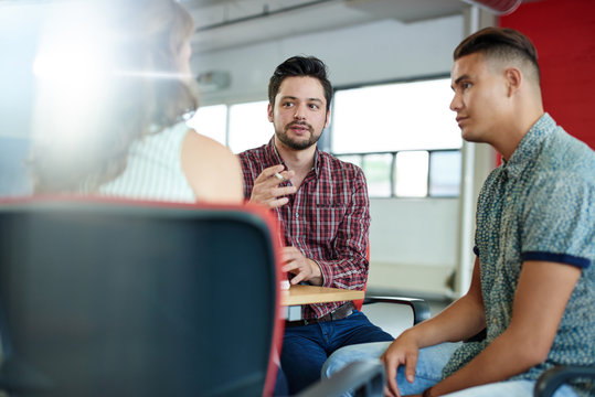 Unposed group of creative business people in an open concept office brainstorming their next project.
