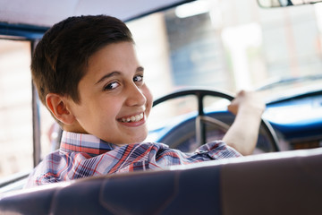 Portrait Child Taking Driving Lesson In Old Car Smiling