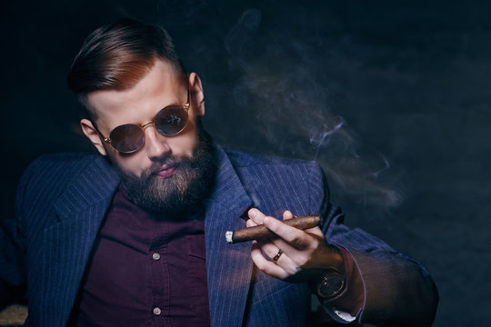 A man in sunglasses smoking a cigar.
