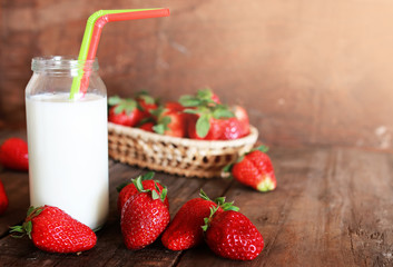 wooden table with strawberries and milk in a glass