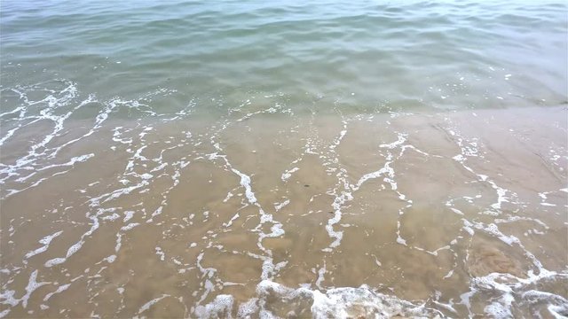 Soft wave of the sea on a sandy beach close up with sound 4K