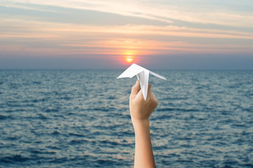 plane paper in children hands and sunset, forward to the target