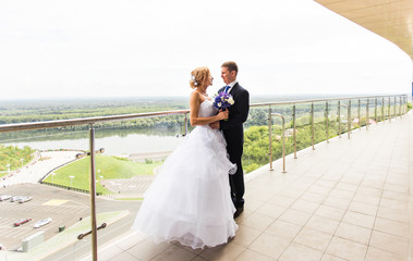 Beautiful bride and groom embracing  on their wedding day outdoors