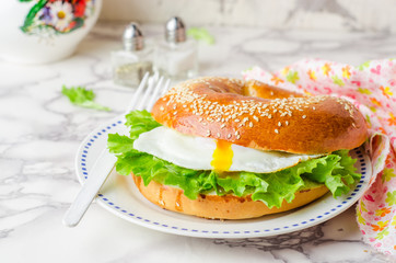 Bagels sandwich with fried egg and salad