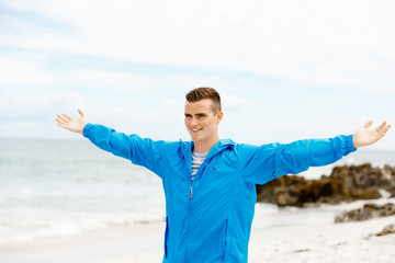 Young man in sport wear with outstretched arms