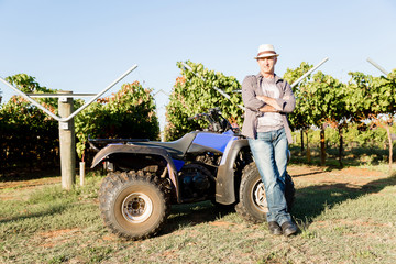 Obraz premium Man standing next to truck in vineyard