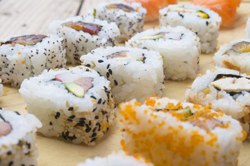 Different Sushi rolls,wasabi and ginger on a plate on wooden bac