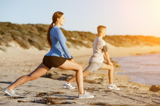 Young couple on beach training together