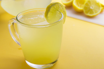 Water and lemon in yellow background