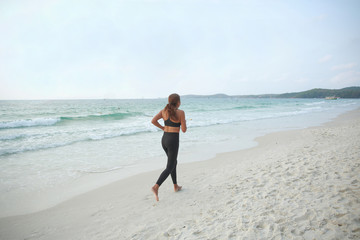 Fototapeta na wymiar A woman jogging on the beach in the morning