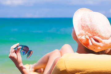 woman relaxing on lounge chair by he beach