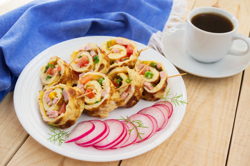 Omelet in a roll on a white plate on a wooden background. Breakfast