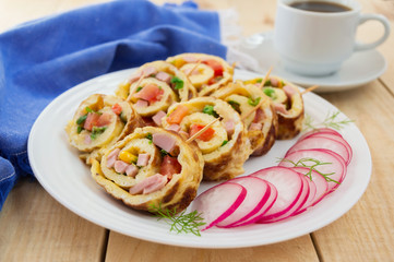 Omelet in a roll on a white plate on a wooden background.Breakfast
