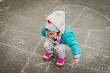 Naklejka premium Girl Playing Hopscotch on playground