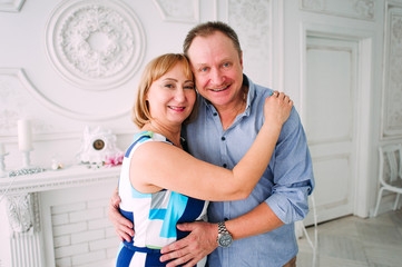 Happy and smiling senior couple in front of white wall