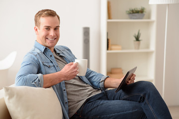 Positive man sitting on the couch 
