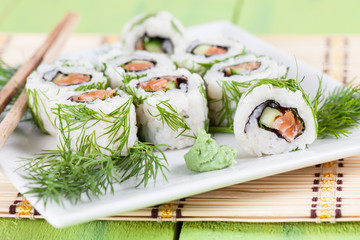 Uramaki sushi with cucumber, raw salmon and dill