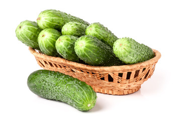 cucumbers in a wicker basket isolated on white background