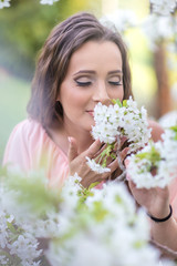 Fototapeta premium Beautiful woman smelling a flower